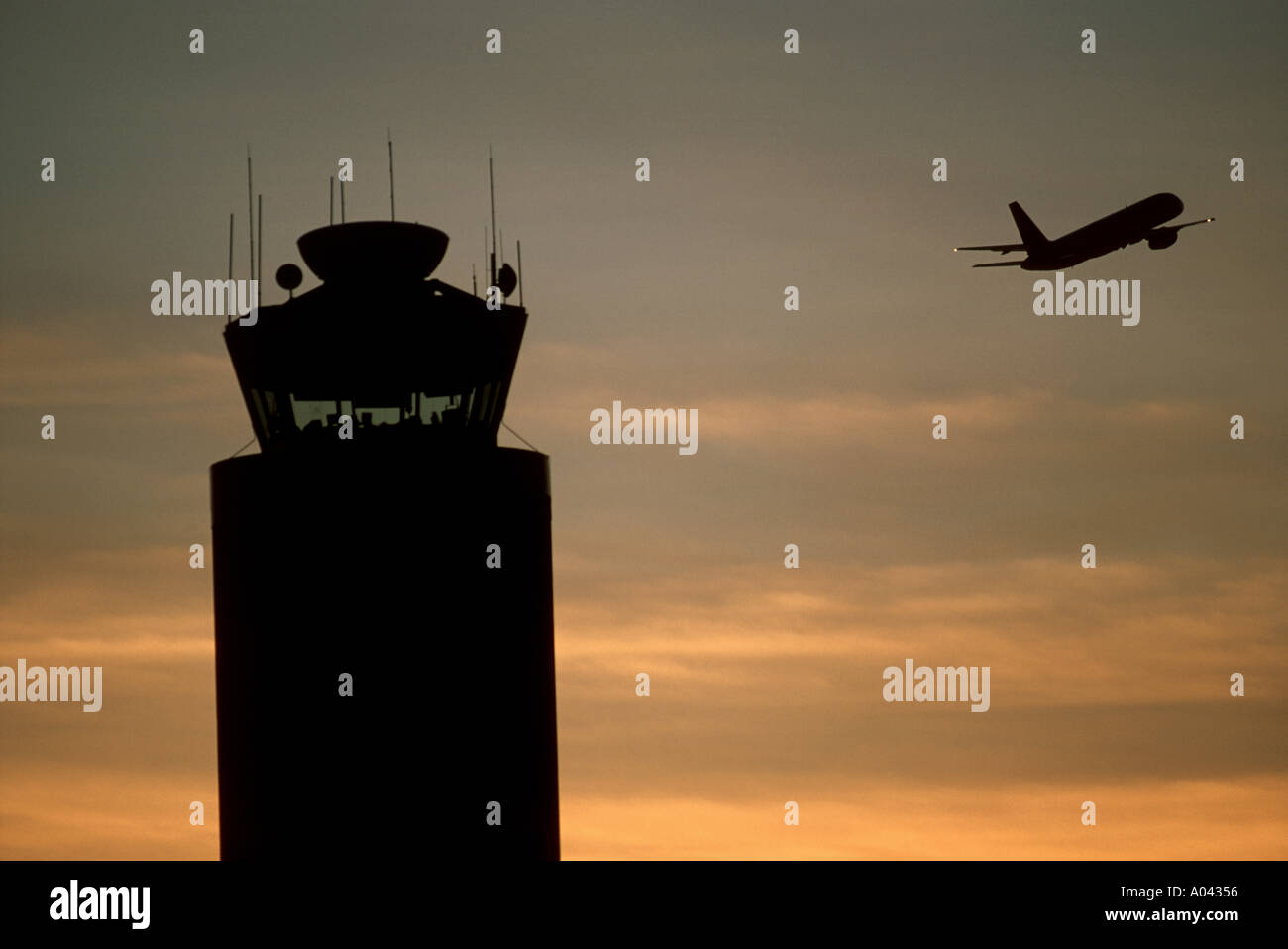 Silhouette of airport control tower plane taking off Stock Photo - Alamy