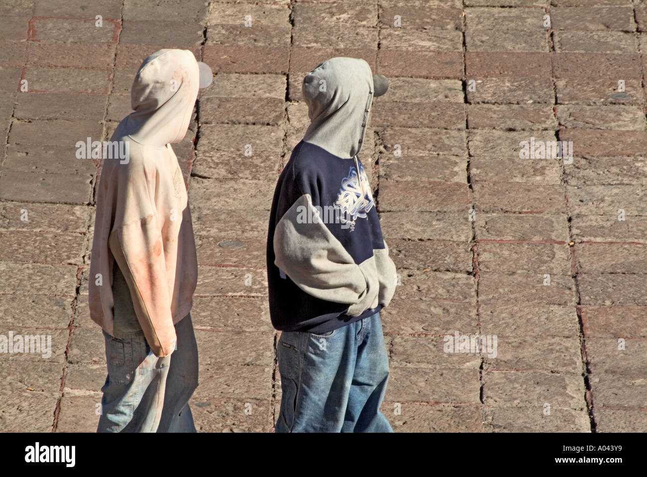 Adolescent boys in hooded sweatshirts wandering streets of Queretaro Mexico Stock Photo