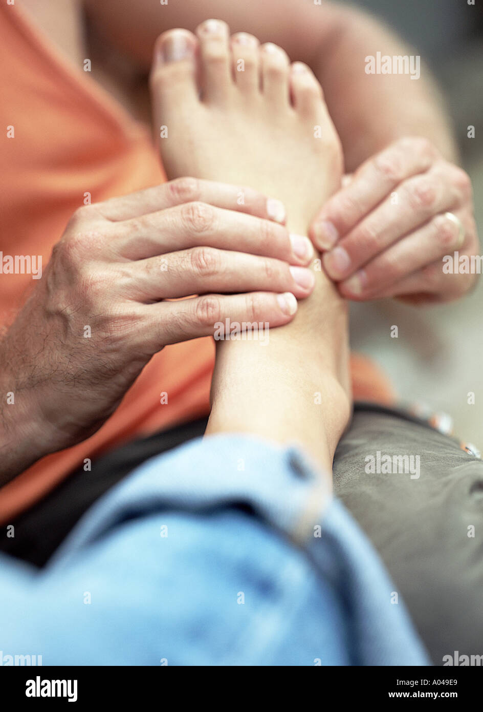 Young man massaging a woman's foot Stock Photo