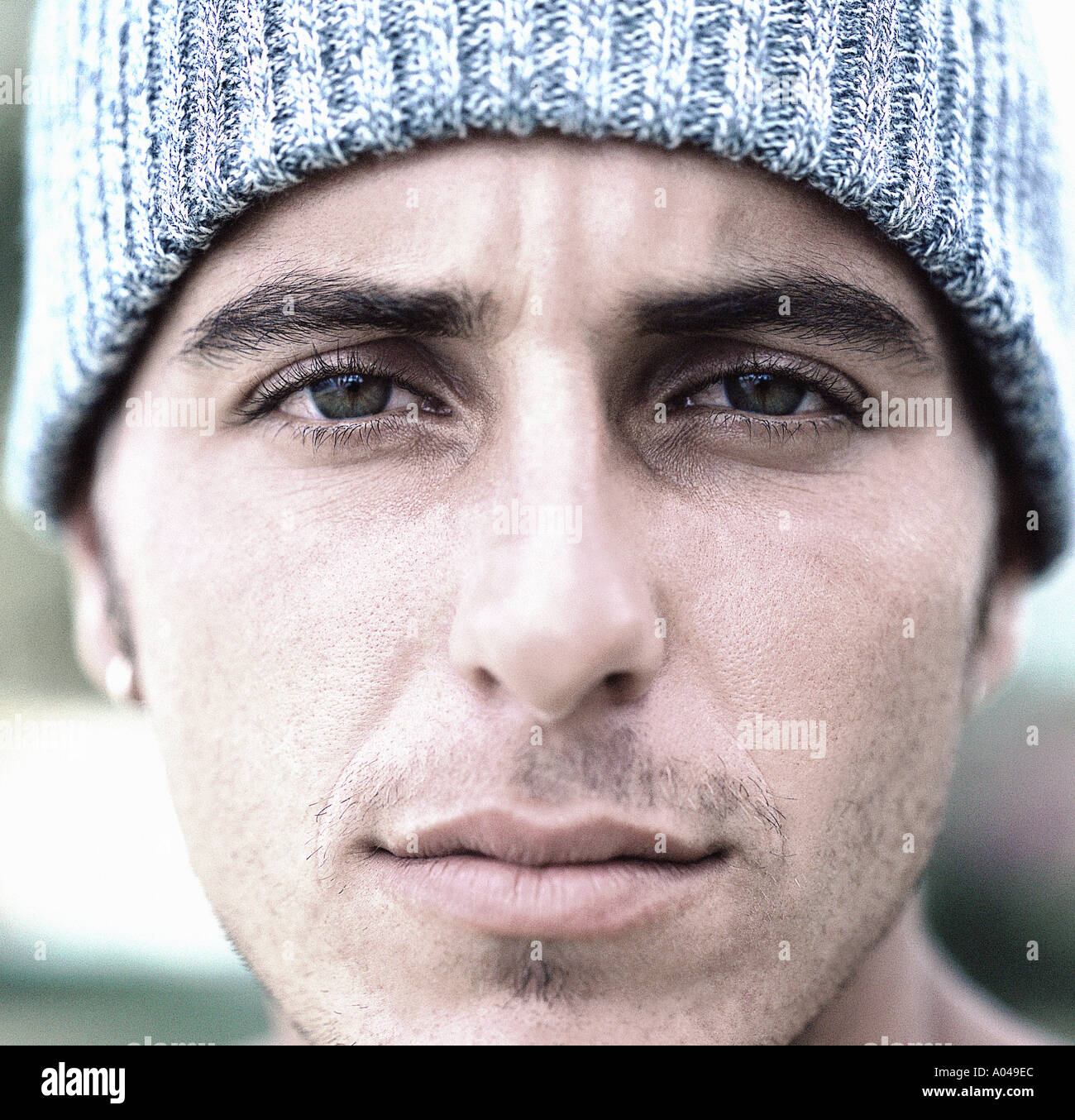 Close up portrait of a young man wearing a grey wool hat Stock Photo