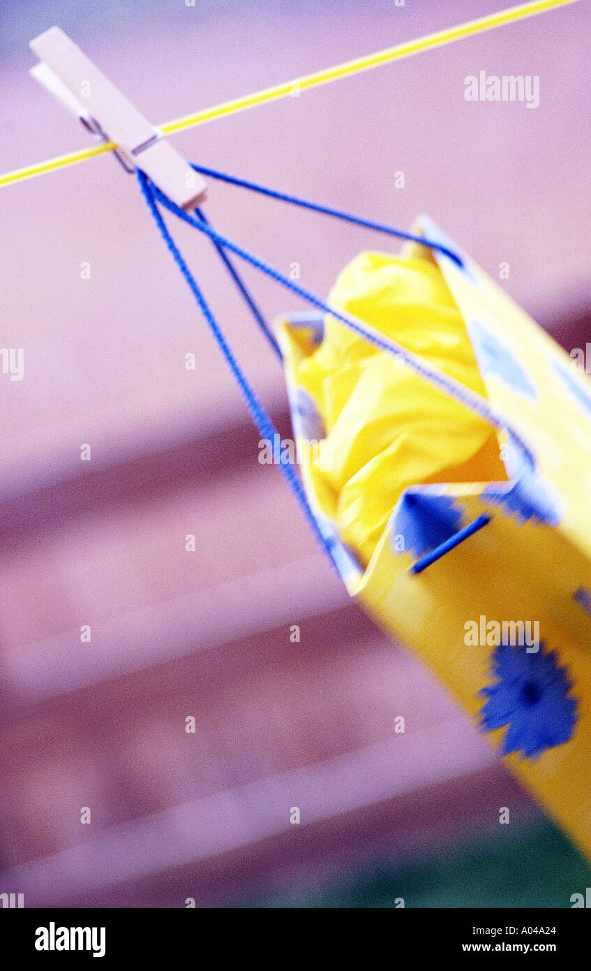 Single yellow shopping bag pegged on to a clothes line Stock Photo
