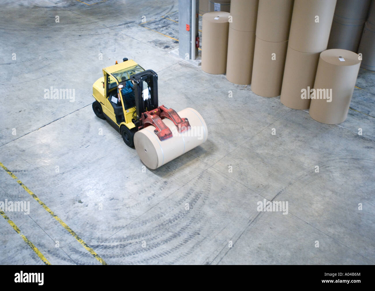Fork lift picking up roll of paper Stock Photo