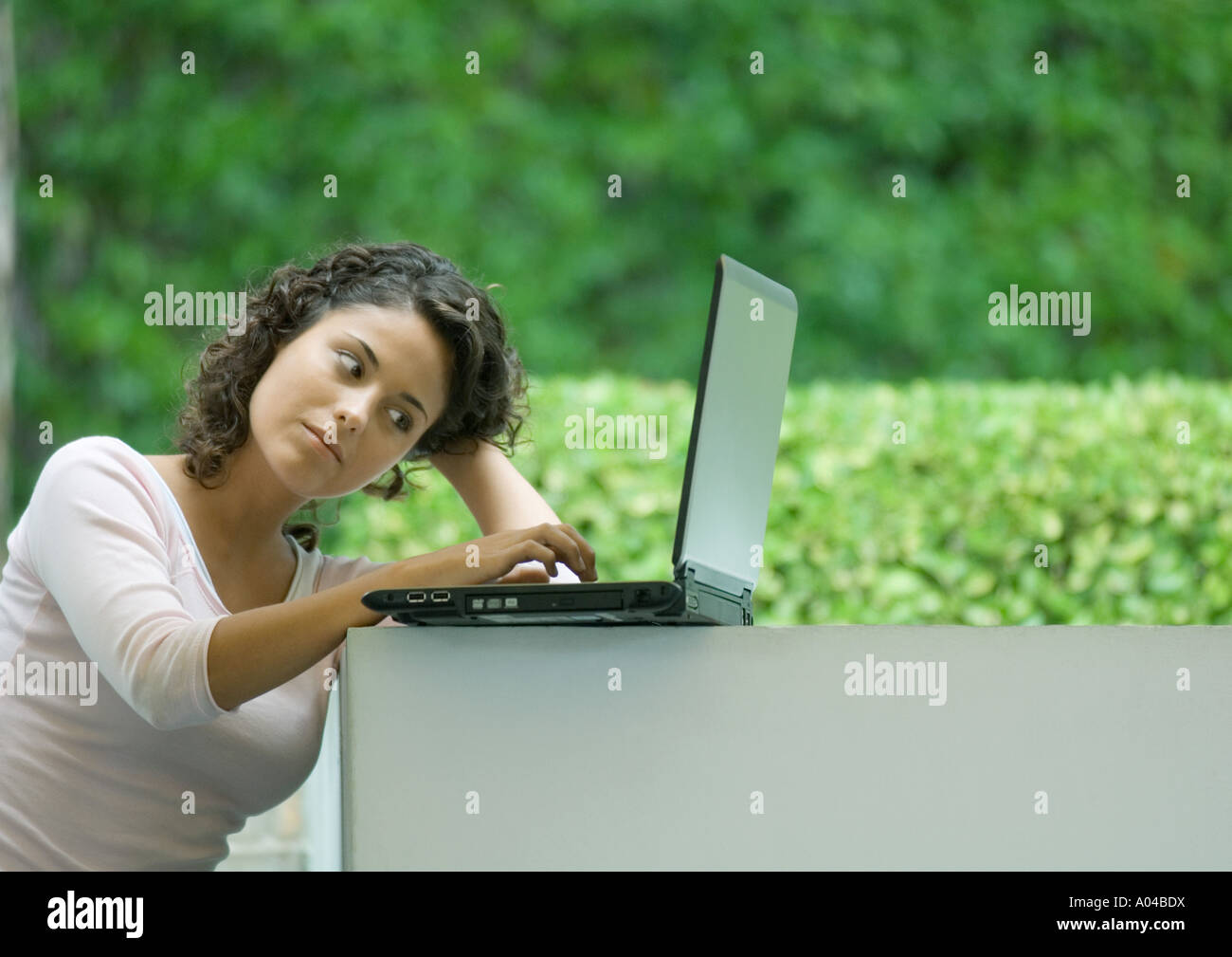 Woman using laptop outdoors Stock Photo