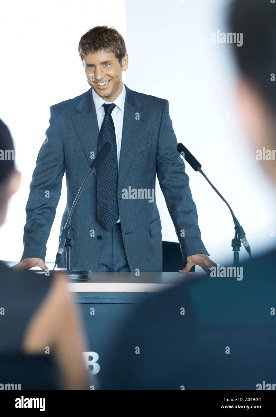 Speaker standing next to microphones during seminar Stock Photo
