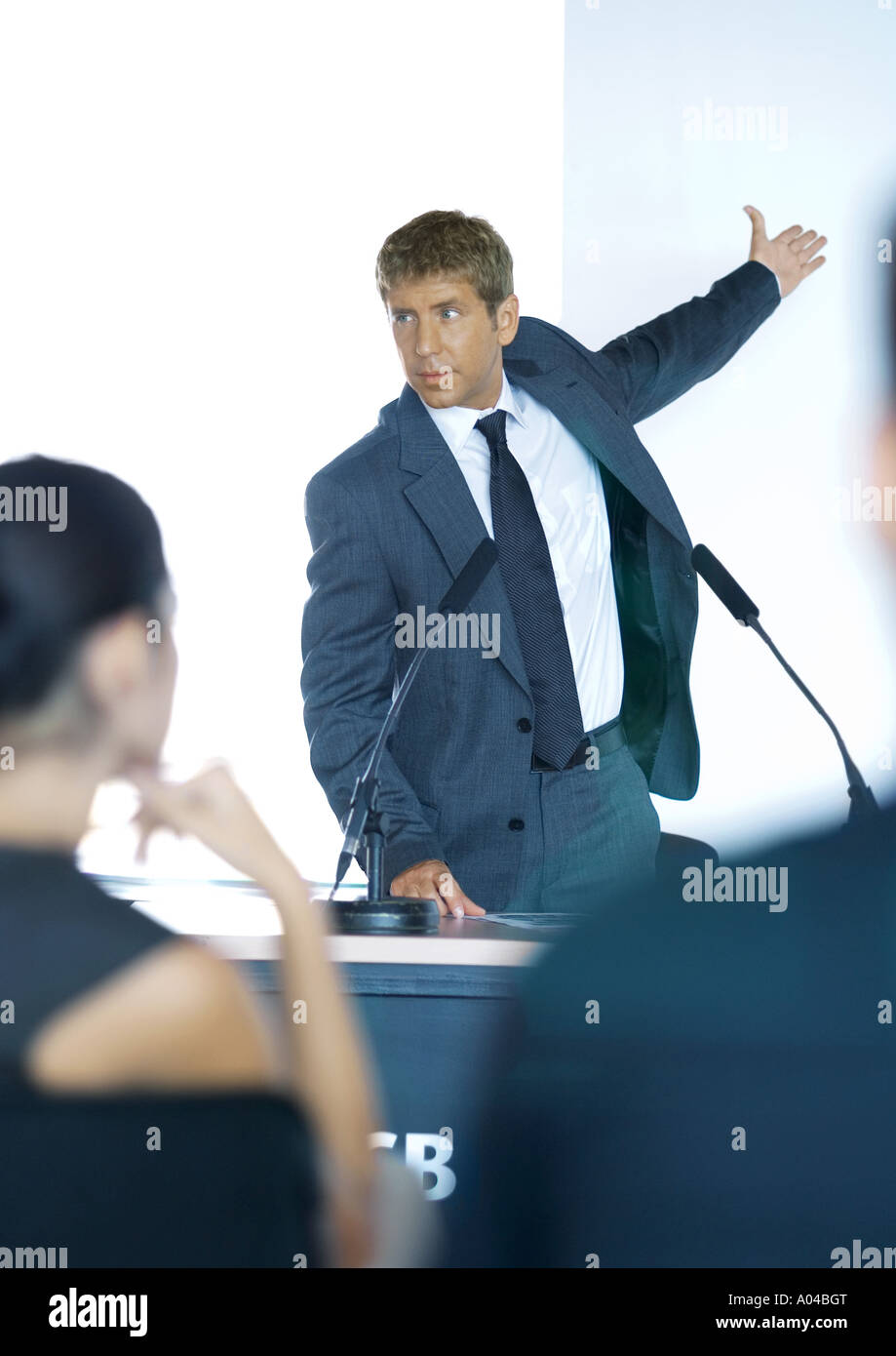Speaker standing next to microphones during seminar Stock Photo