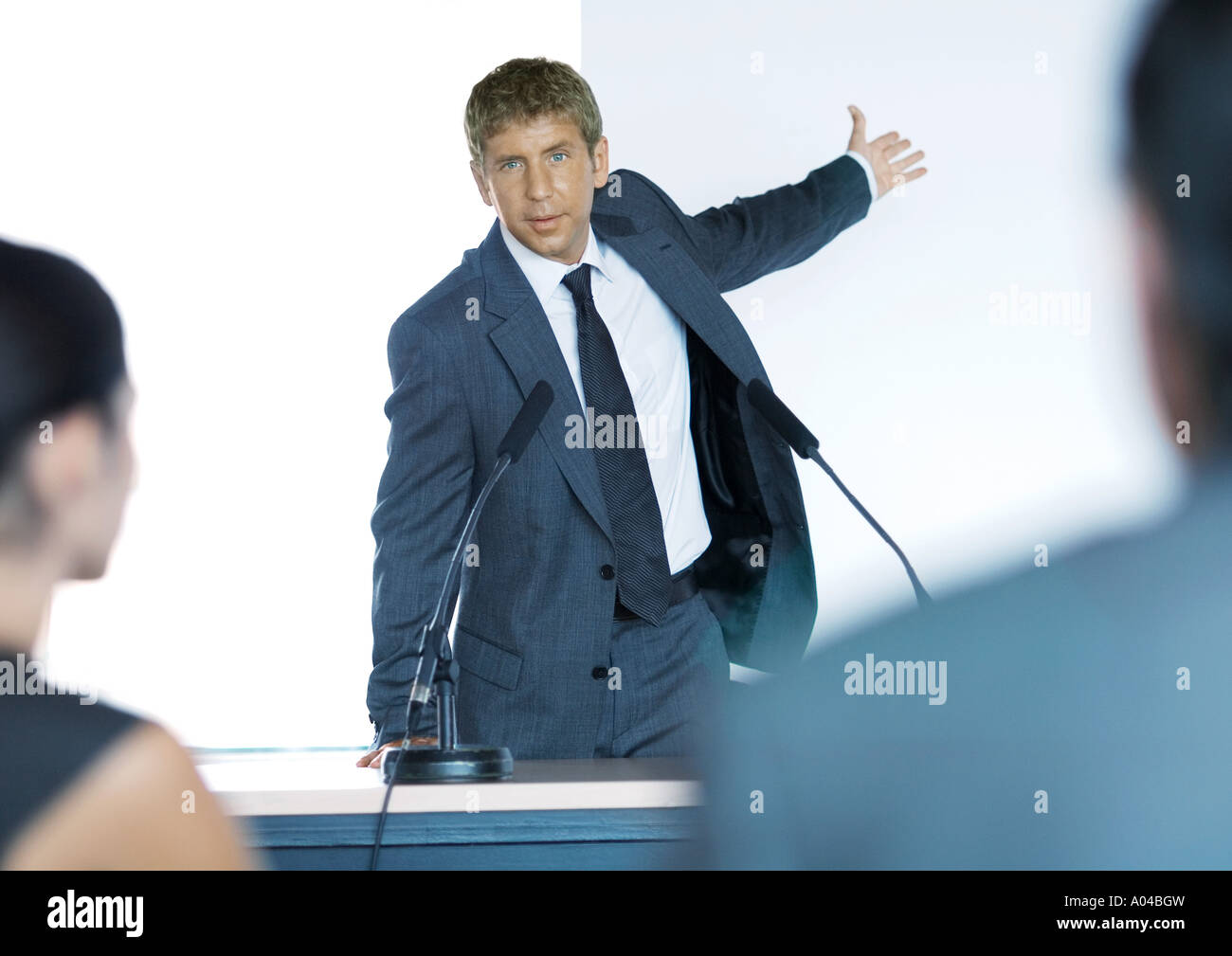 Speaker standing next to microphones during seminar Stock Photo