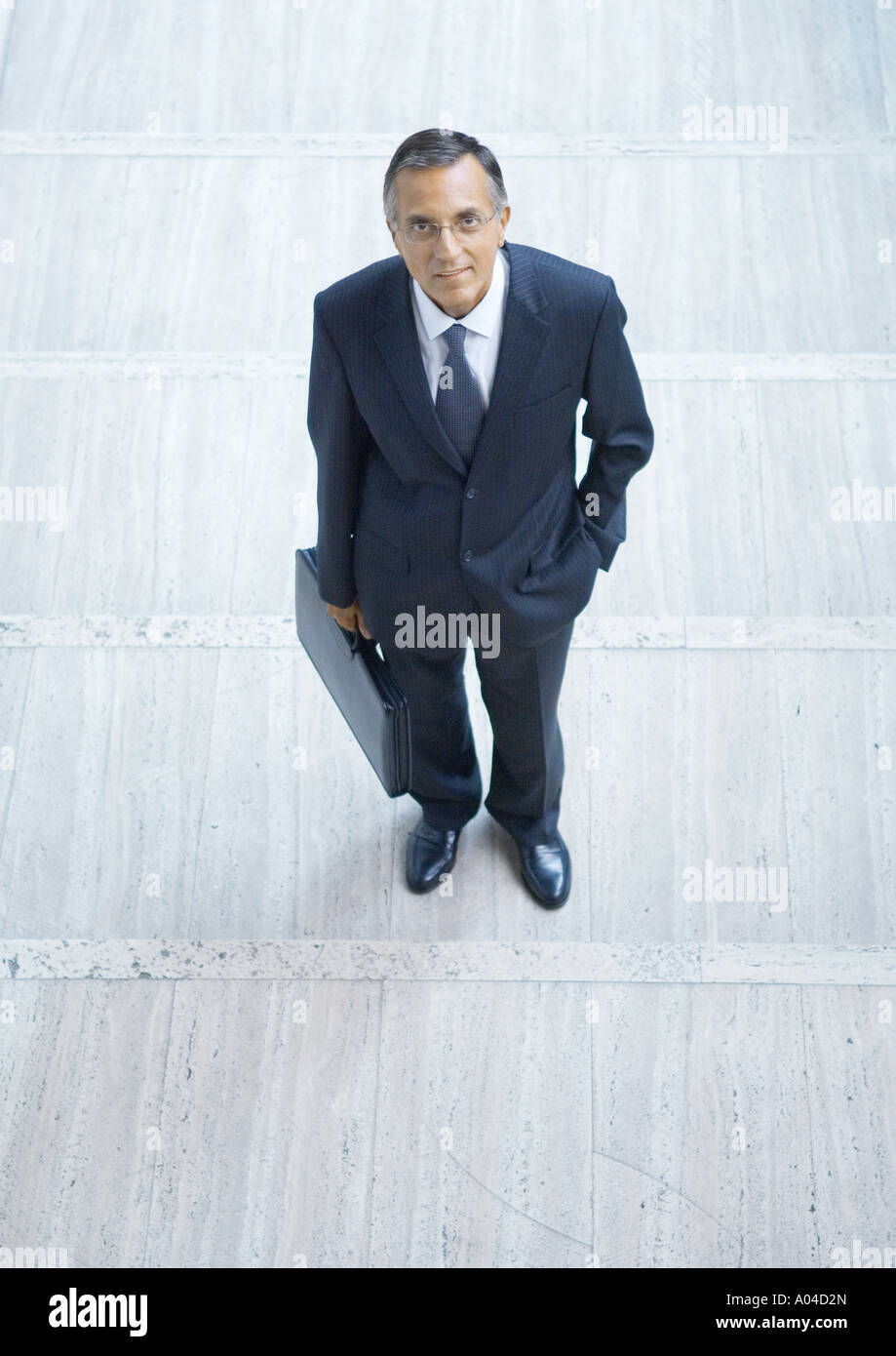 Businessman standing with briefcase, high angle view Stock Photo