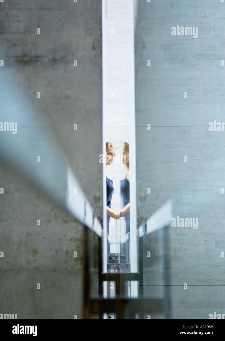 Woman seen through narrow opening, with reflection Stock Photo