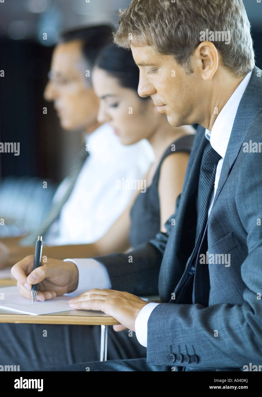 Executives sitting in seminar, taking notes Stock Photo