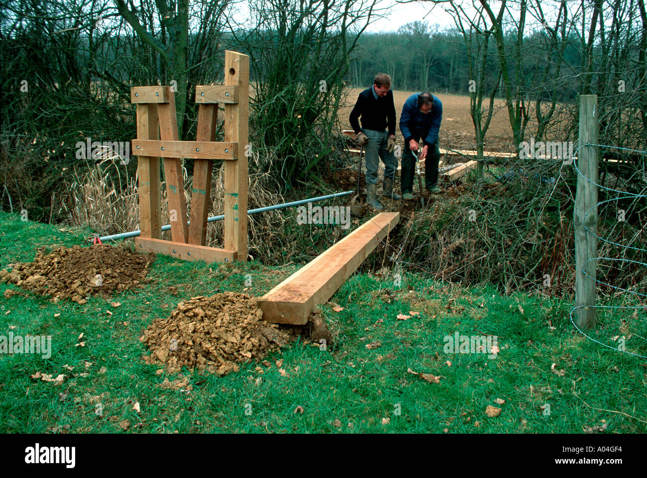 Cotswold warden with volunteer group constructing new bridge over