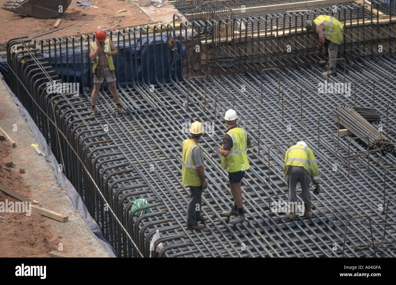 Construction workers preparing steel reinforcement forming part of new basement floor slab to office block Stock Photo
