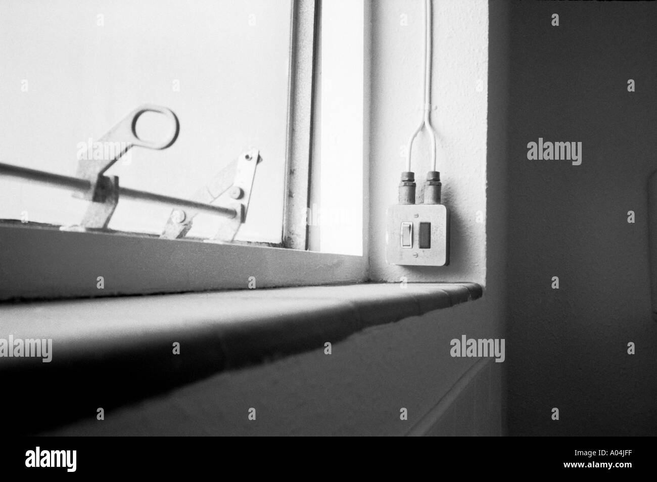 Light switch by the side of a toilet window in old building Stock Photo