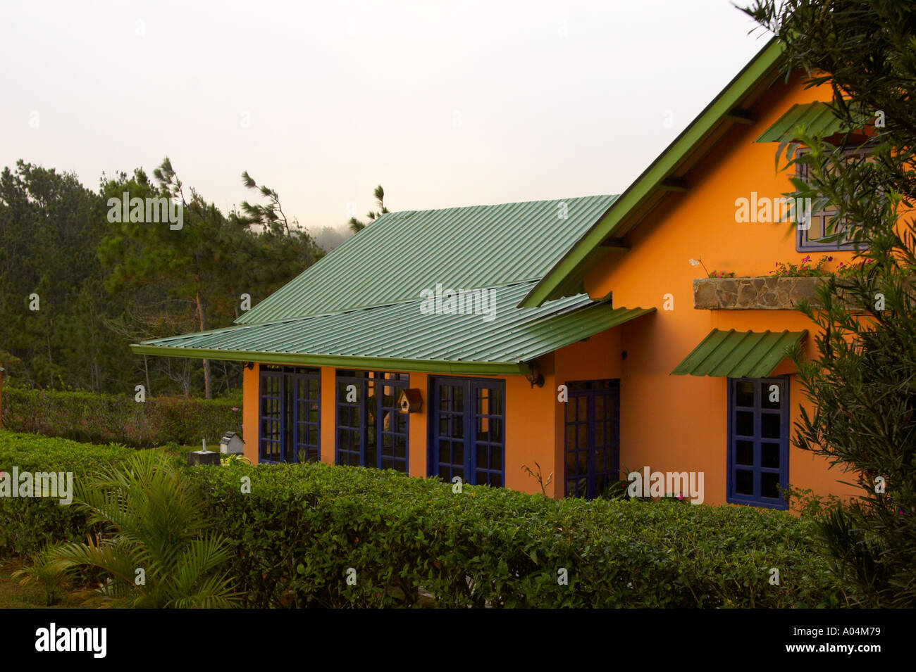 Yellow house with green roof bathed in golden light Cerro Azul Panama Central America Stock Photo