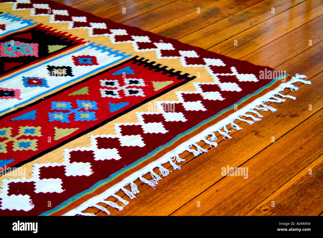 Colorful kilim rug on polished wooden floor Stock Photo