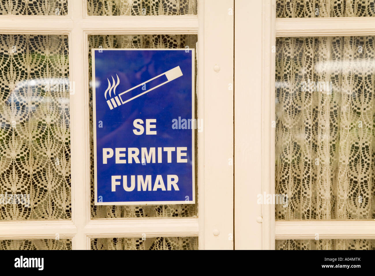 Sign on restaurant door in Spanish language saying Se Permite Fumar or Smoking Permitted Stock Photo