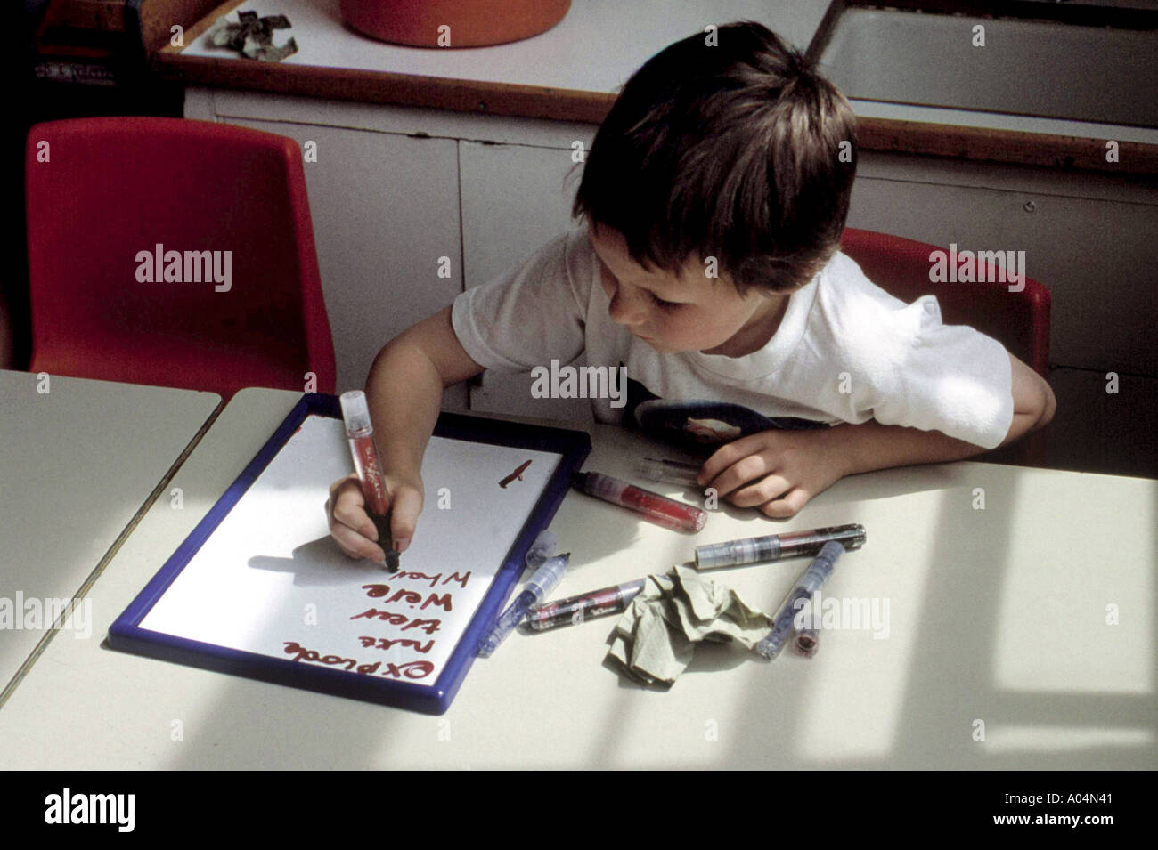 Primary Classroom With 6 To 7 Year Old Boy Writing At His Desk