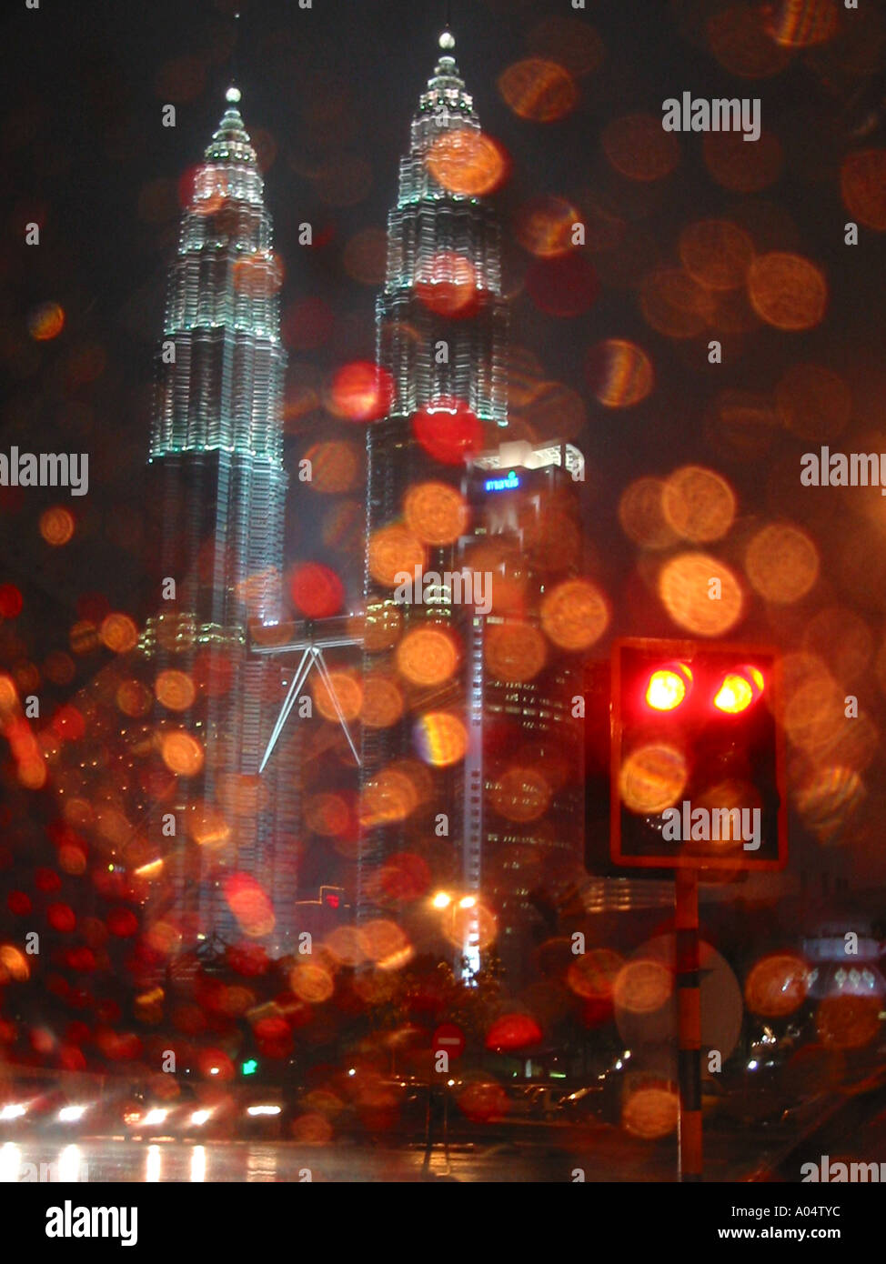 Petronos Twin Towers in Kuala Lumper, Malayasia. Blurred Rain drops at night from a Taxi in the rain while waiting at traffic Stock Photo