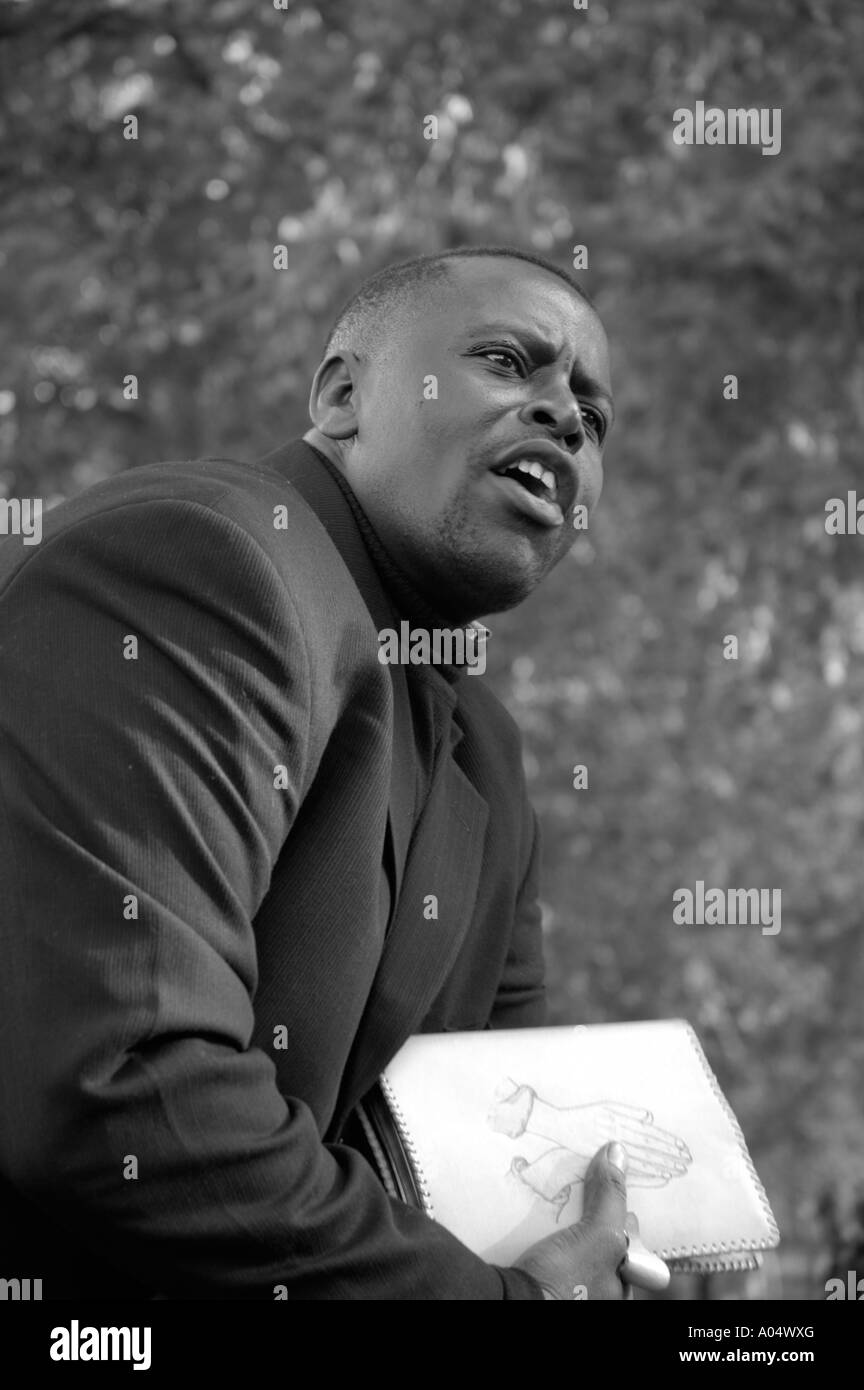 Well dressed black evangelical Christian preacher holding white Bible speaking at Speaker's Corner, Hyde Park, London, England Stock Photo