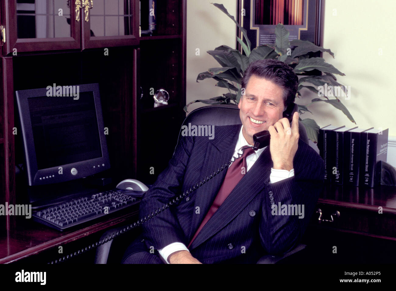 portrait of business man on phone in office with happy expression on his face Stock Photo