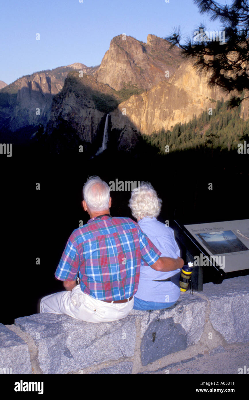 senior husband and wife couple watching sunset on vacation in Yosemite National Park in California USA Stock Photo