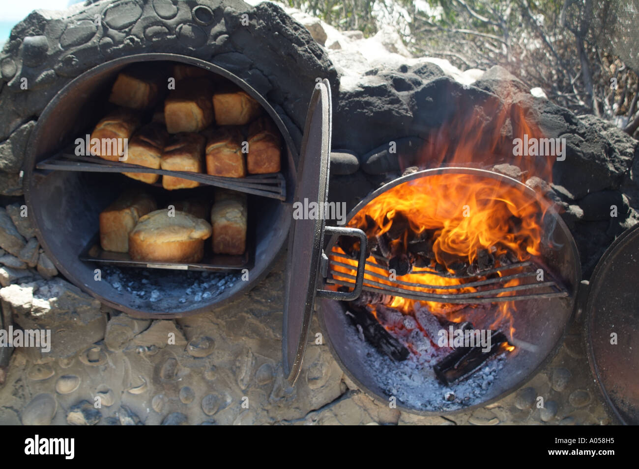 Fresh bread being baked in open fire oven on the beach Langebaan