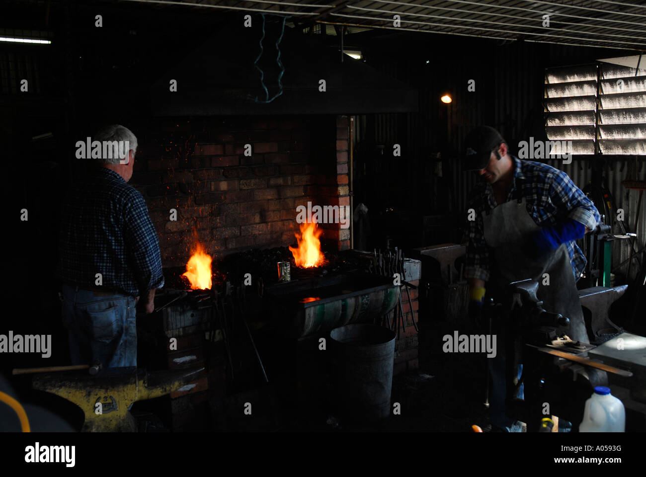 two men working in a blacksmith shop Stock Photo
