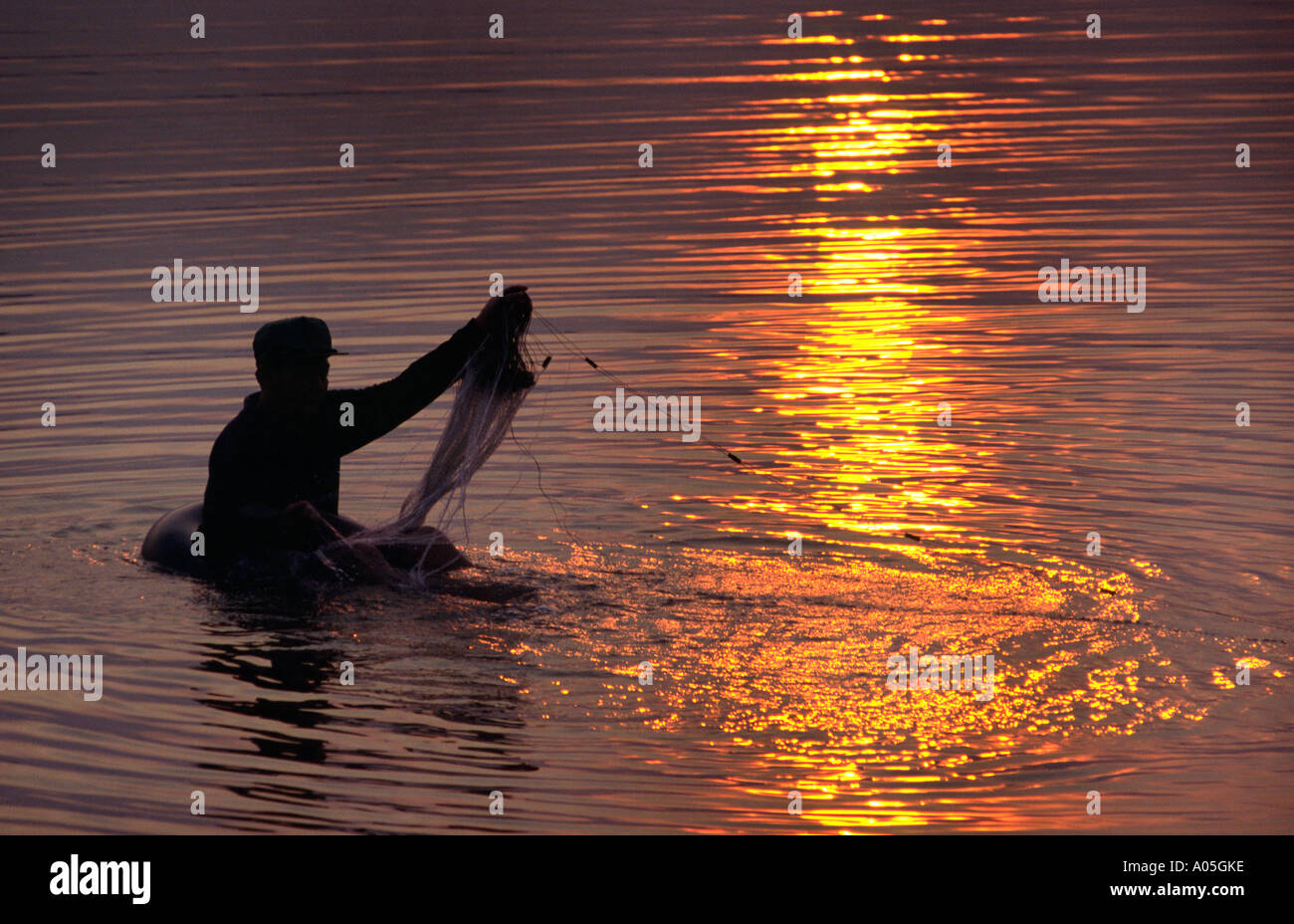 Sunset fishing from an inner tube. Mekong River, Vientiane, Laos Stock