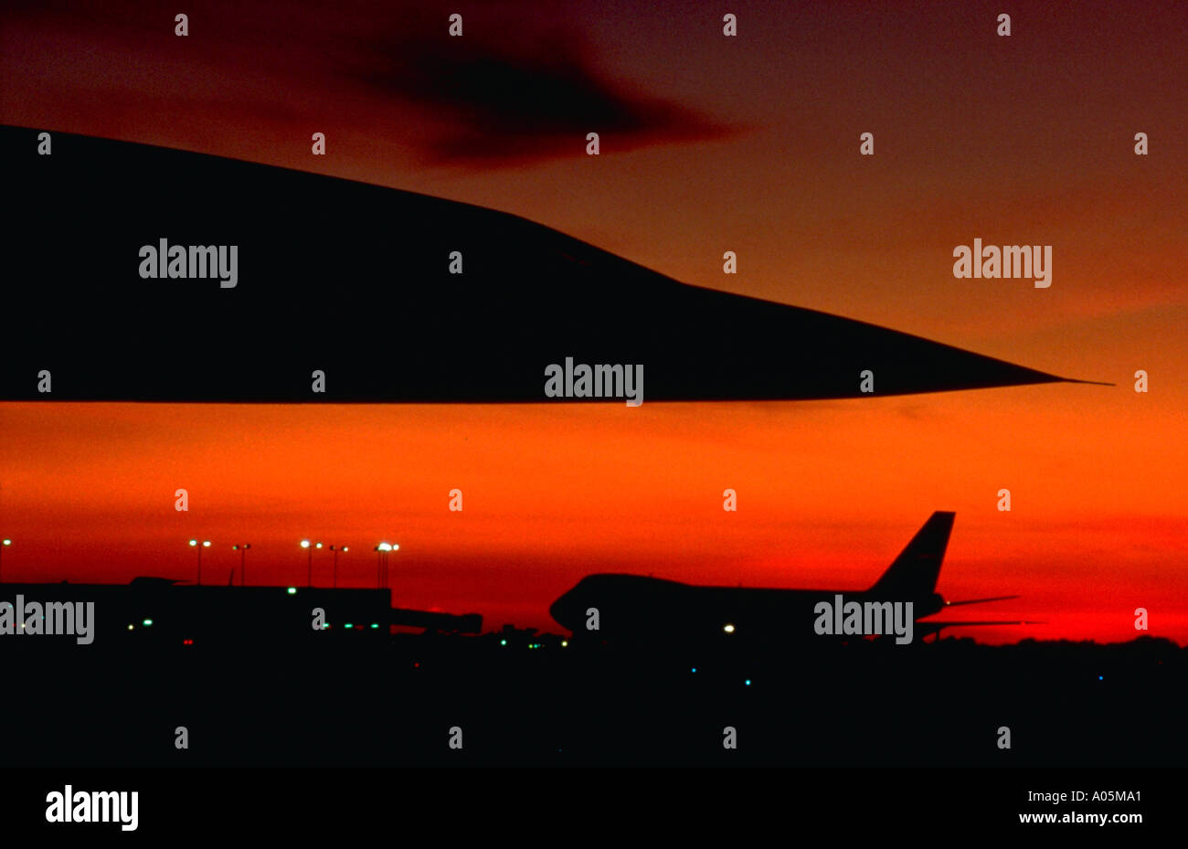 The distinctive pointed nose of the Concorde towers above the silhouette of a 747 against a Florida sunset sky Stock Photo