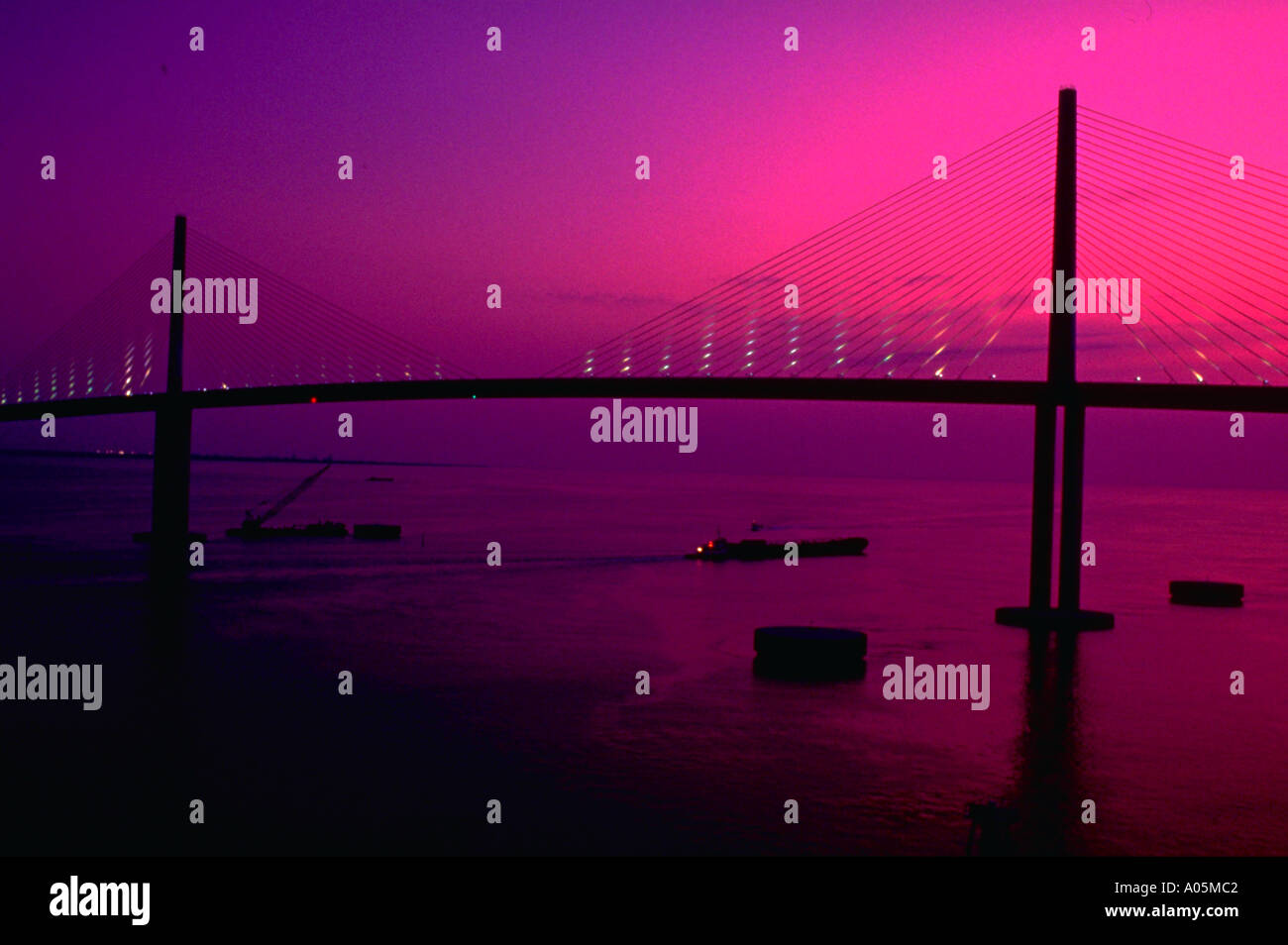 The majestic Sunshine Skyway Bridge crosses Tampa Bay against the purple pre dawn sky near Tampa Florida USA Stock Photo