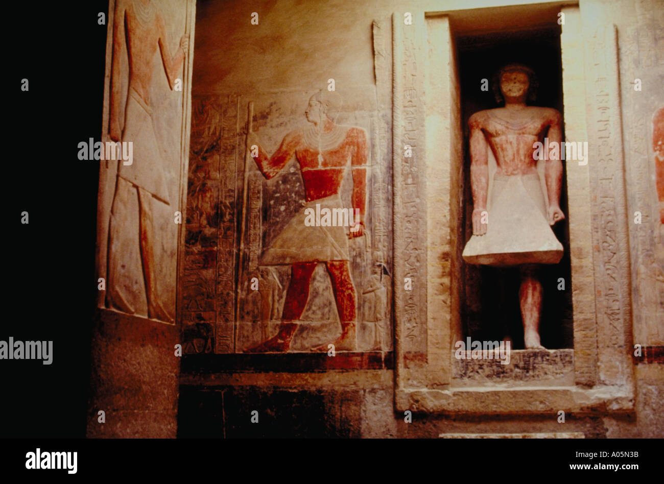 Egyptian hieroglyphics and sculptures carved into the walls of a tomb