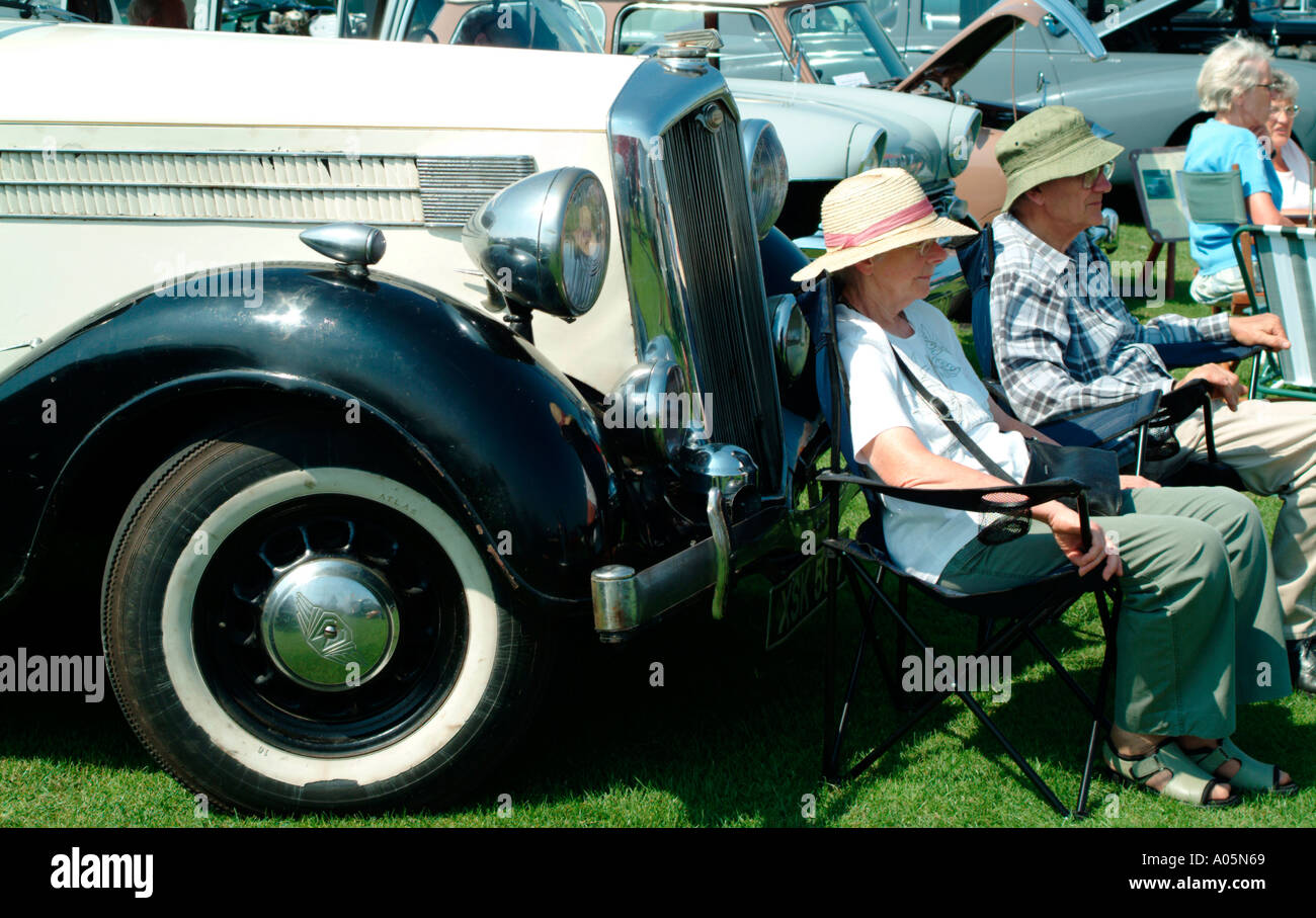 older man and woman sitting with classic car Stock Photo