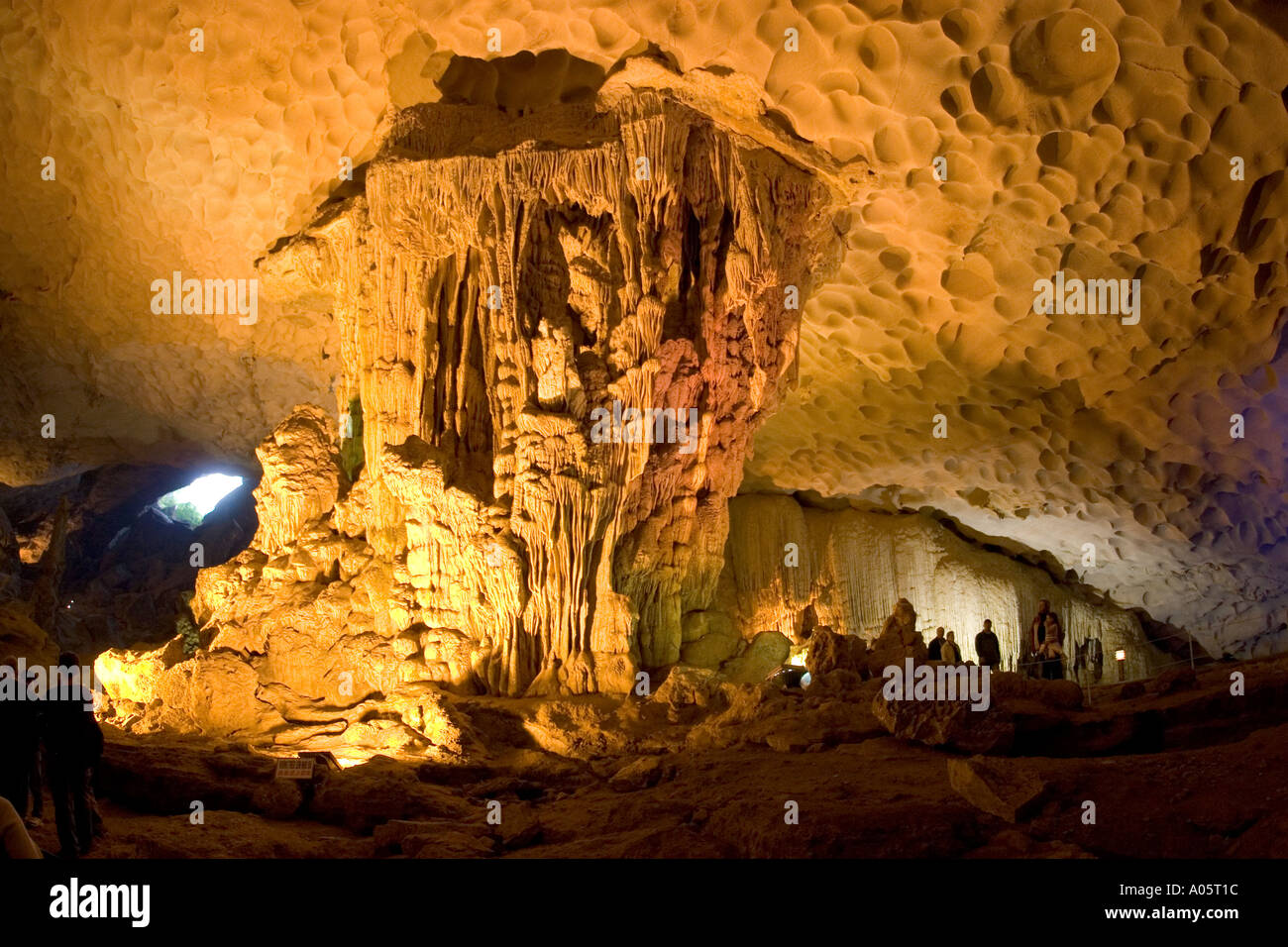 Vietnam northeast Halong Bay Hang Sung Sot cave visitors amongst illuminated underground stalactites and stalagmites Stock Photo