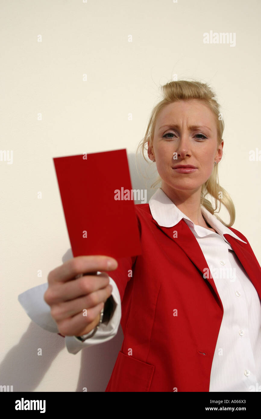 A smart woman is holding a red card as she looks at the camera Stock Photo
