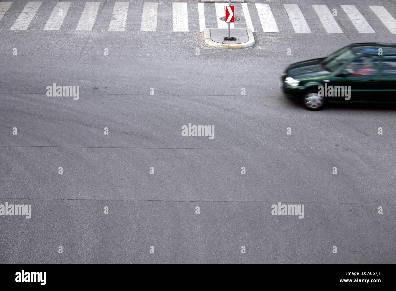 A person driving the car is seen near the zebra crossing Stock Photo