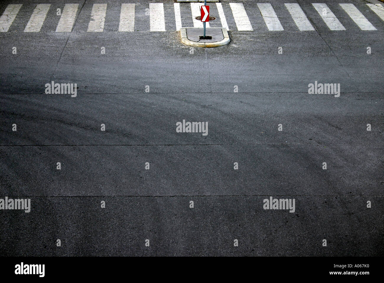 A signboard is seen near the zebra crossing on the road Stock Photo