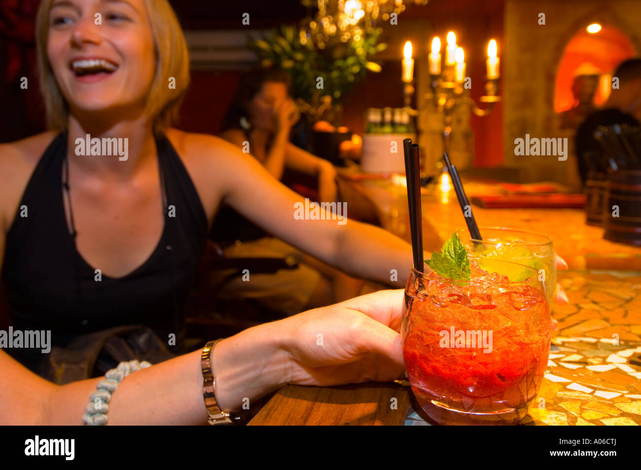 Two smiling girls enjoying cocktail drink in Budda Bar on Rynek Glowny