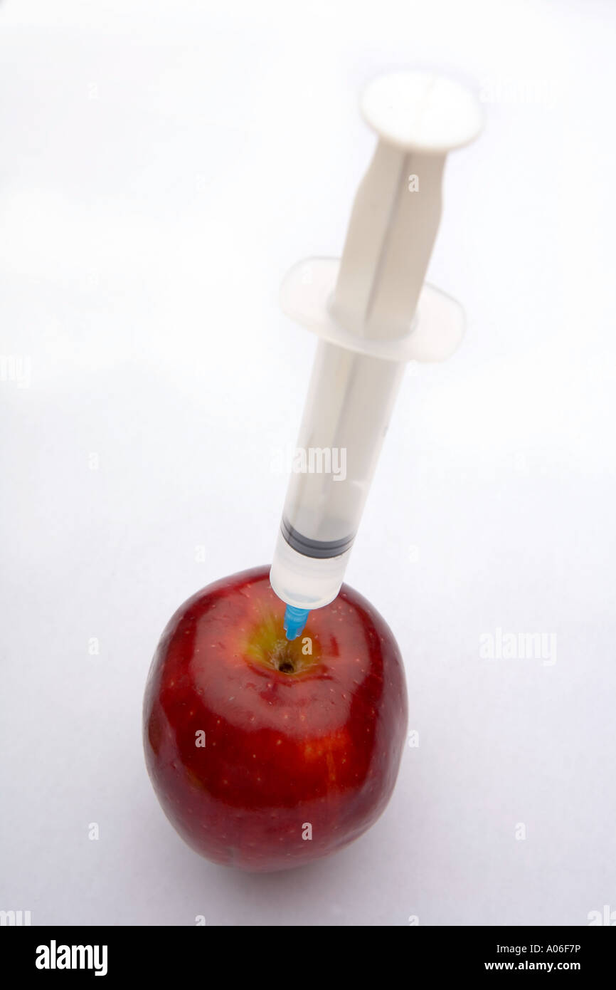 Apple being injected with a clear liquid. Stock Photo