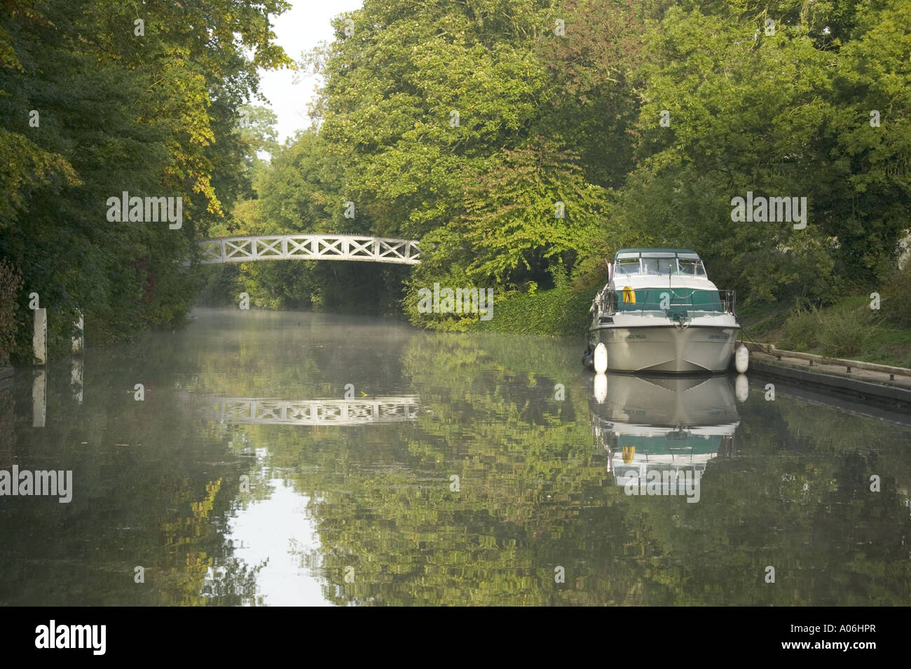Cookham Lock bridge and a pleasure craft reflecting in the still River Thames water Stock Photo
