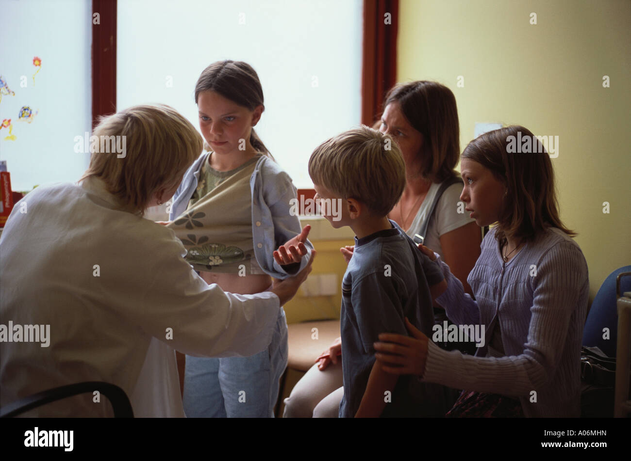Woman Doctor examines nine year old girl for skin condition prague Czech Republic while family look on Stock Photo