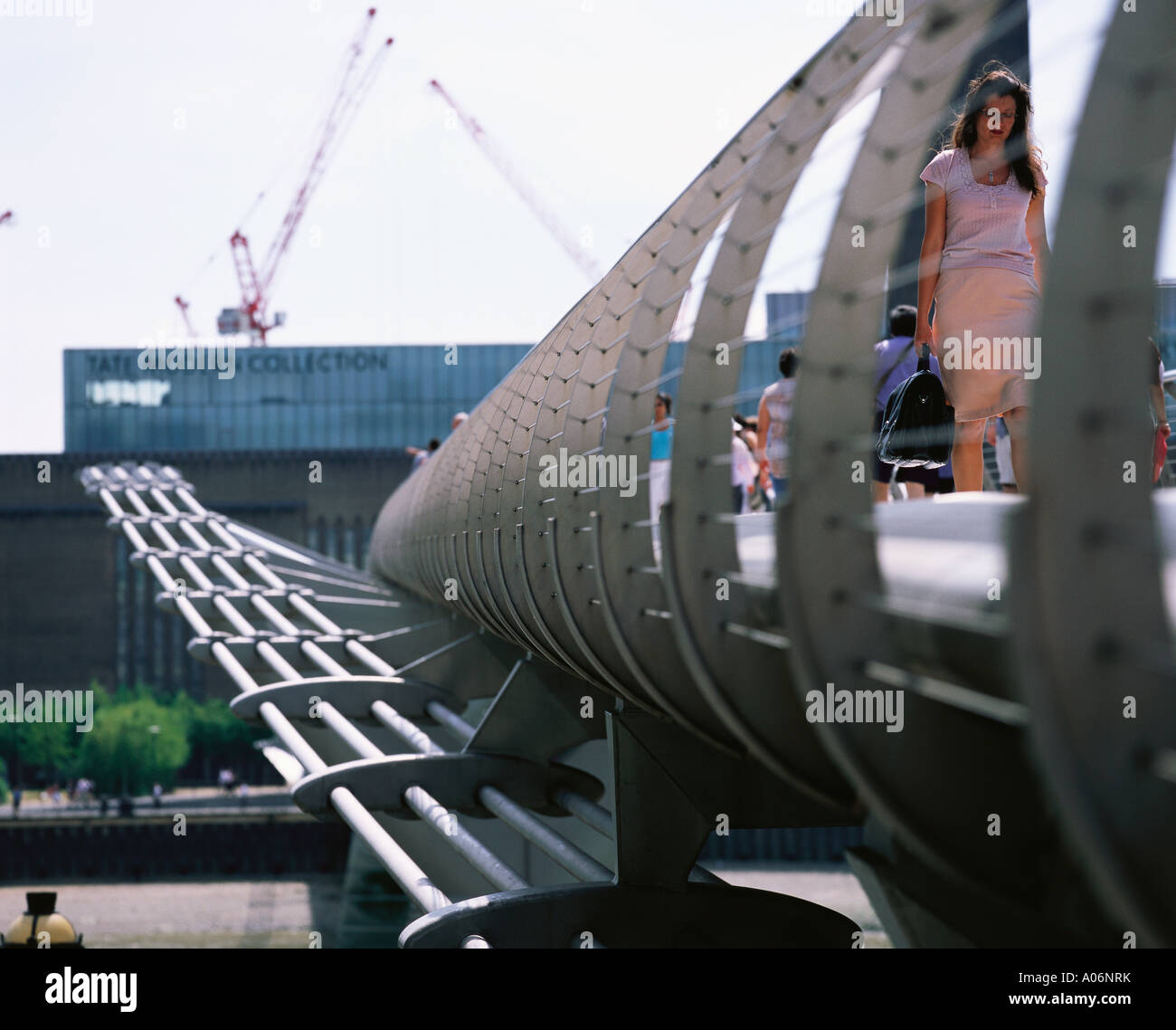 Woman crosses Millenium Bridge from Tate Modern London Stock Photo