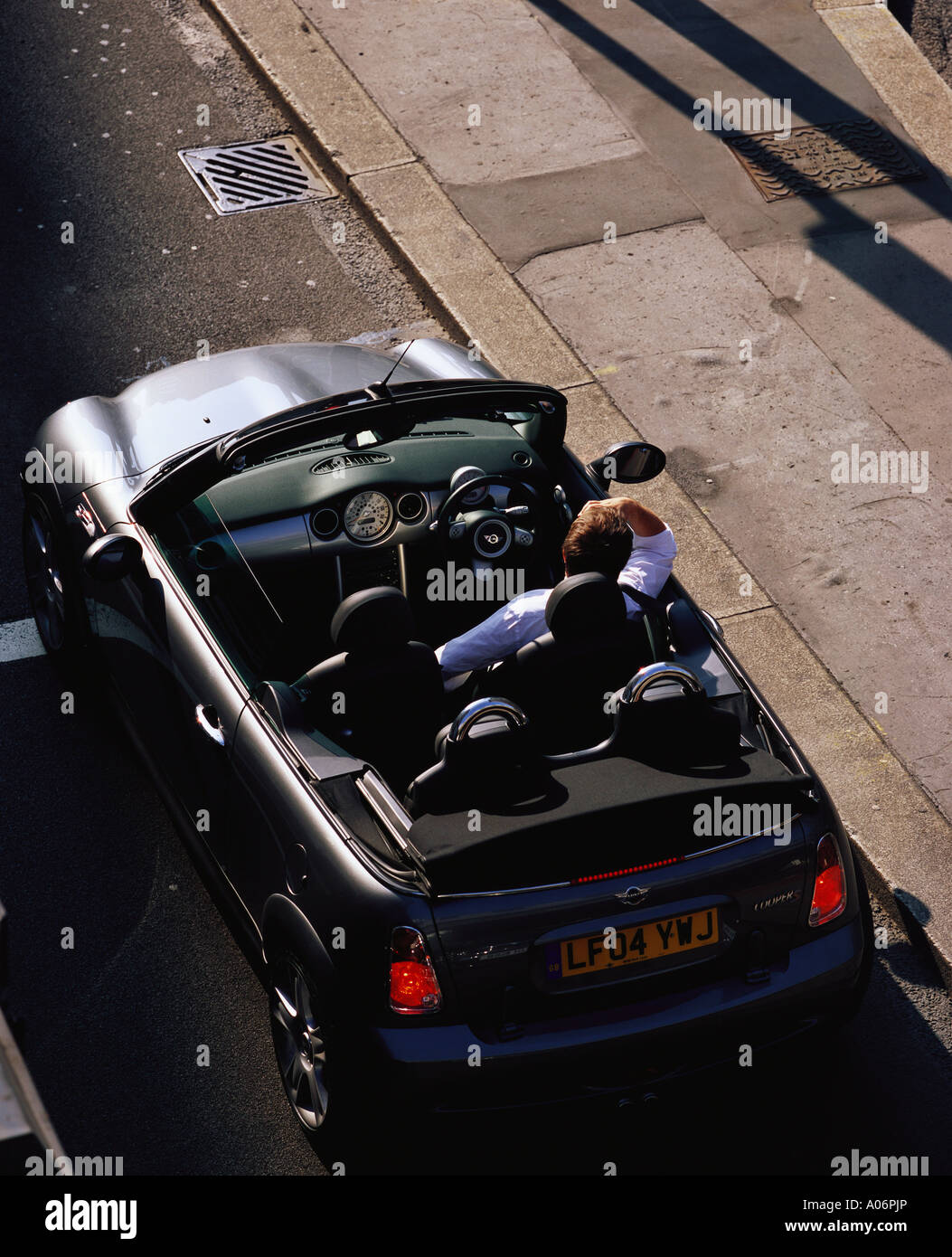 Driver of Rover Mini convertible waiting at traffic lights london Stock Photo