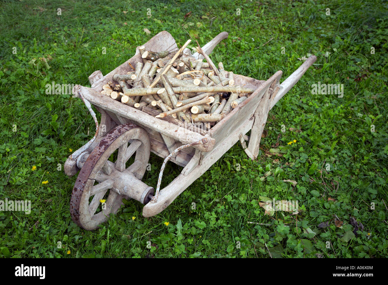 Firewood in an old wooden wheelbarrow Stock Photo