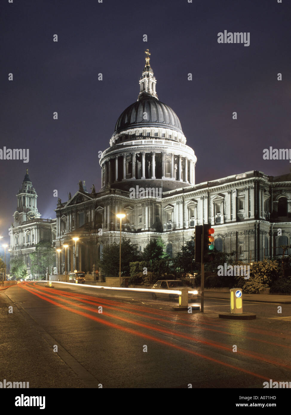 Night street scene City of London traffic trails & floodlights on Sir Christopher Wren iconic historical dome St Pauls cathedral building England UK Stock Photo