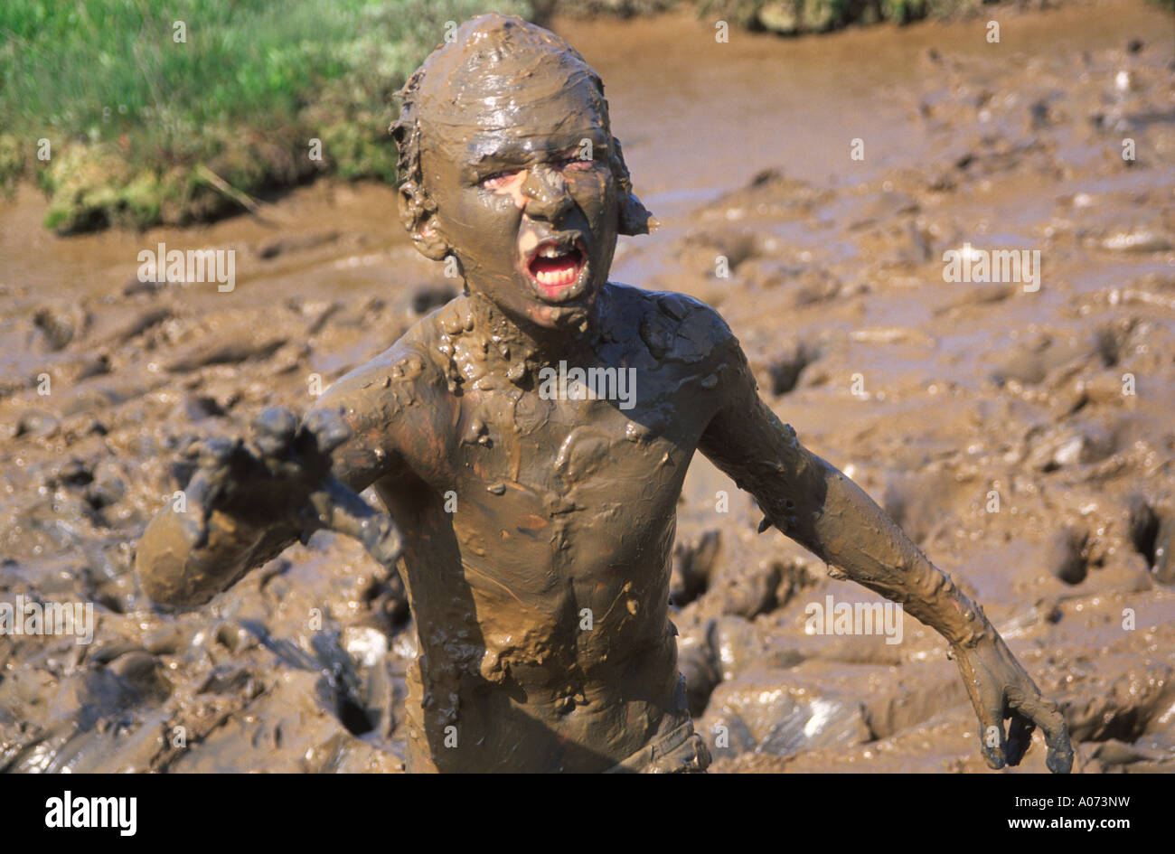 monster-like-child-playing-in-thick-mud-with-head-and-body-covered-A073NW.jpg