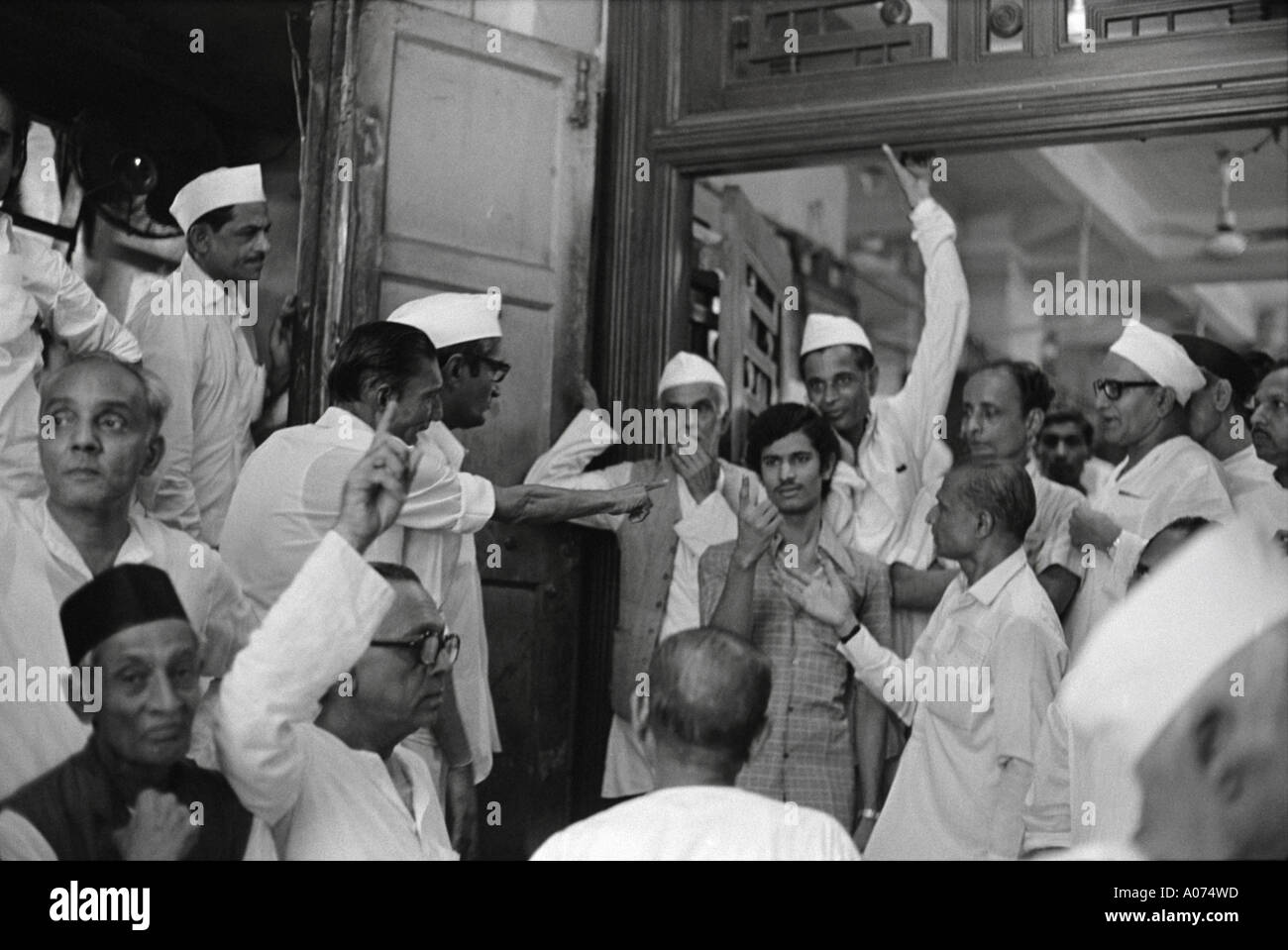 Old vintage 1970s Stock Exchange men dressed in Indian dress kurta Gandhi topi cap hat trading at Bombay Mumbai Maharashtra India Indian Asia Asian Stock Photo