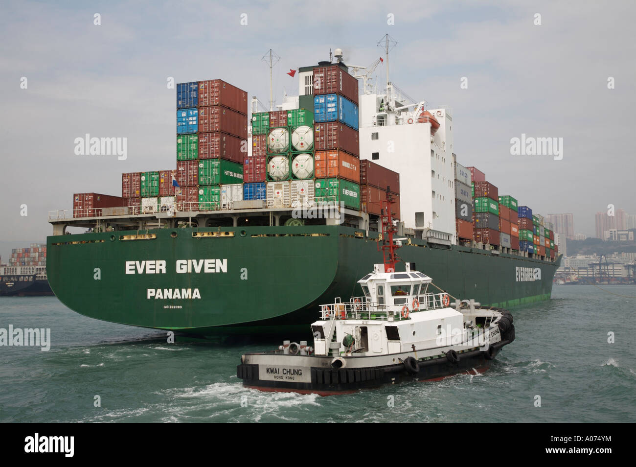Tugboats manoevering around an ocean going containership at kwai chung container port in hong kong sar china fareast asia Stock Photo