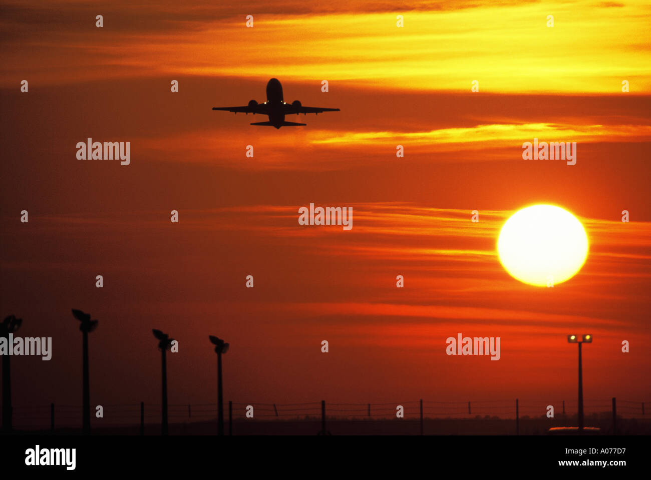 Aircraft taking off near London Heathrow against dramatic sunset Stock Photo