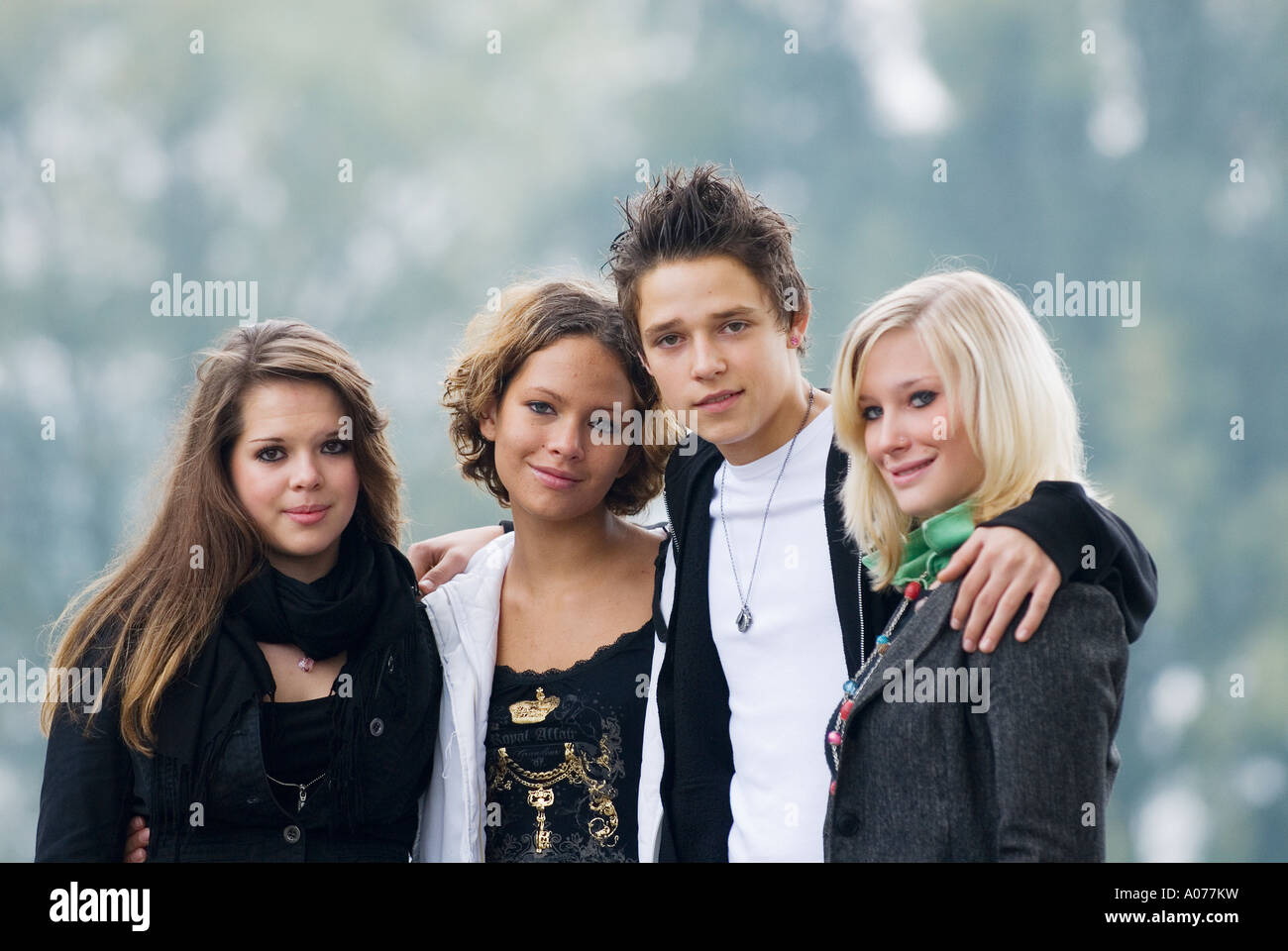 group of four caucasian teenagers, one boy and three girls smile into  camera Stock Photo - Alamy