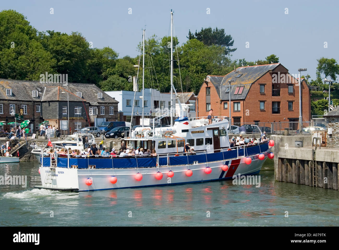 Padstow harbour with tour boat Jubilee Queen about to depart for tour into Camel estuary & beyond with full load of passengers on a hot summers day Stock Photo