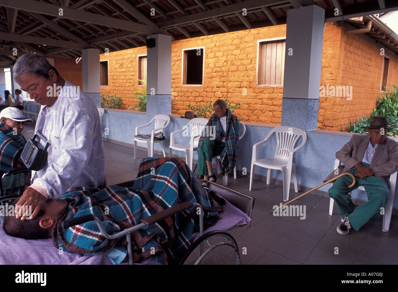 Geriatric Hospital takes in paralyzed patients and dependent on bedside care. Handicapped patient takes confort to another one. Stock Photo